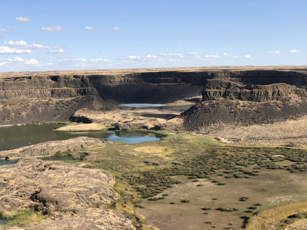 Photo of Dry Falls, WA State Park with 200 ft basalt cliffs towering over small lakes